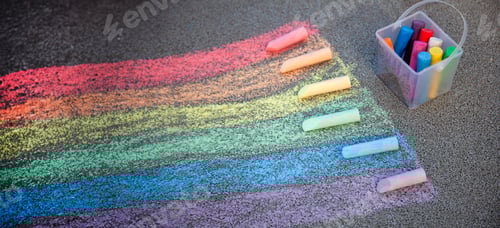 Preview: Sidewalk chalk drawing. A rainbow painted on the asphalt. Kids activities