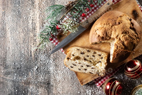 Preview: Traditional Christmas panettone with red tie and christmas ornaments on wooden table