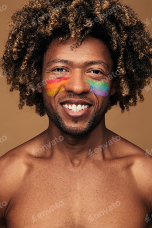 Preview: Cheerful homosexual man with LGBT flag on cheeks
