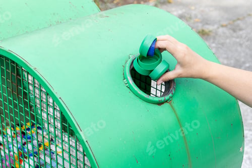 Preview: Hand throwing plastic caps into a urban recycling bin