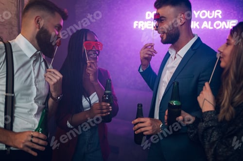 Preview: Happy group of friends dancing on a party in a club