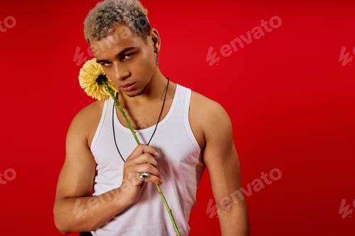 Preview: Striking young man showcases fashion style in vibrant red studio setting