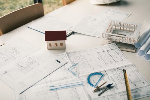 Preview: Close up model house on table and blueprint in the office room.