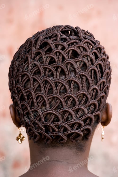 Preview: A woman's head with braided patterned hair and earrings.
