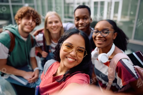 Preview: Happy Indian student taking selfie with her colleagues at the university and looking at camera.