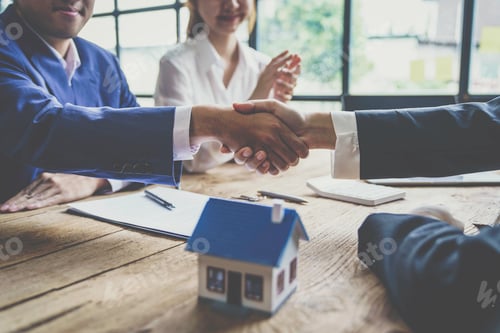 Preview: Estate agent shaking hands with customer after contract signature after completing negotiations to b