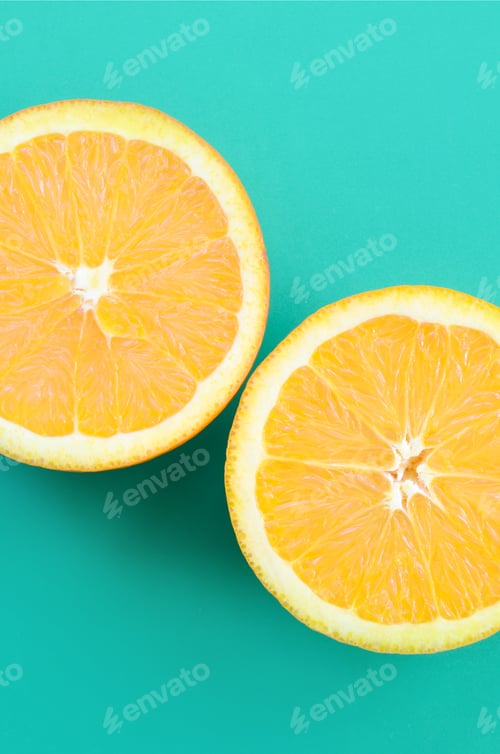 Preview: Top view of a several orange fruit slices on bright background in turquoise green color