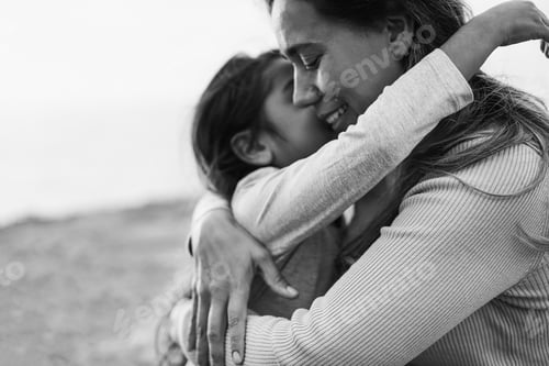 Preview: Happy latin mother and daughter hugging each others during spring time outdoor