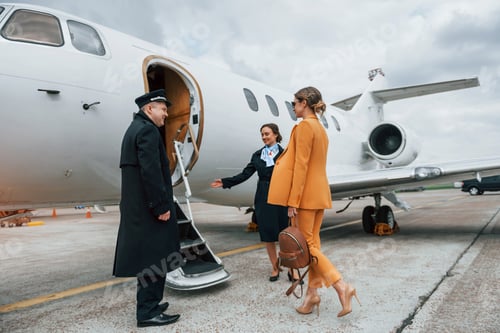 Preview: A young woman in yellow clothes is accompanied by an airline workers