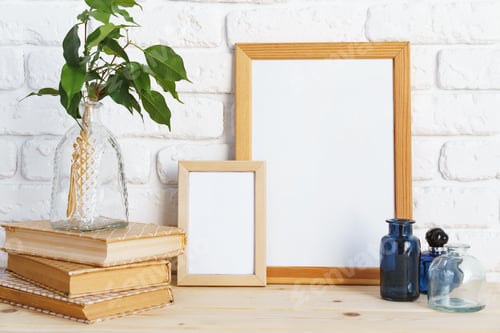 Preview: Wooden frame mockup on table with modern vase and books