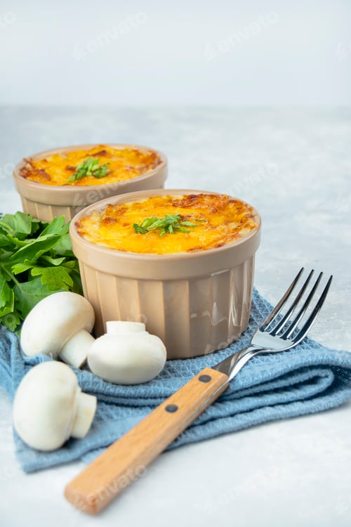 Preview: Casserole with cheese, sauce and mushrooms. French dish julienne. European cuisine. Copy space.