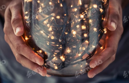 Preview: Hands cradling a jar filled with twinkling fairy lights
