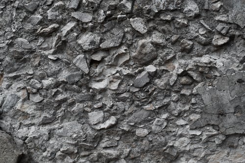 Preview: Rough dark gray stone wall made of cobblestones and concrete. Texture uneven stone background