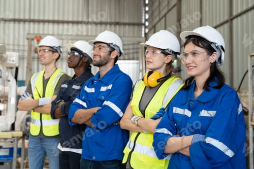 Preview: Group of robotic engineers standing and arms crossed at factory workshop