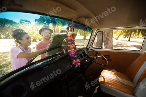 Preview: Friends looking at map seen through windshield