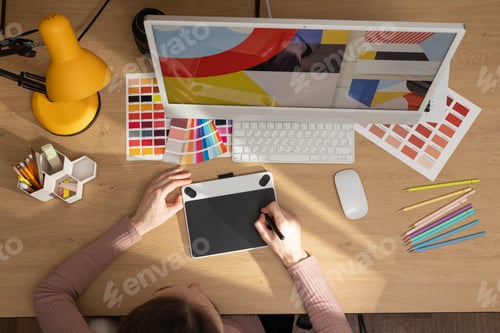 Preview: Sitting on the chair. Designer's software on the screen. Woman is working