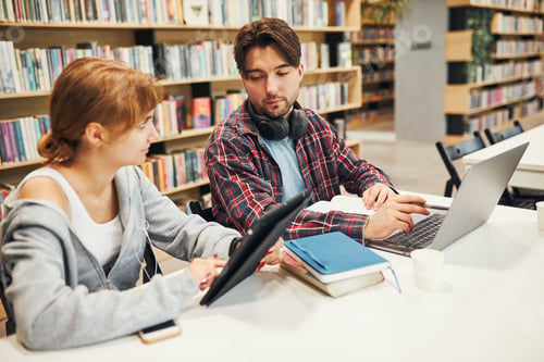 Preview: Students learning in university library. Students discussing and learning together sitting at desk