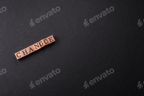 Preview: The inscription chance or change with wooden cubes on a dark concrete background