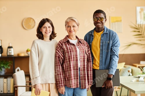 Preview: Portrait of Three Happy Multiethnic Colleagues Posing in Beige Office Room