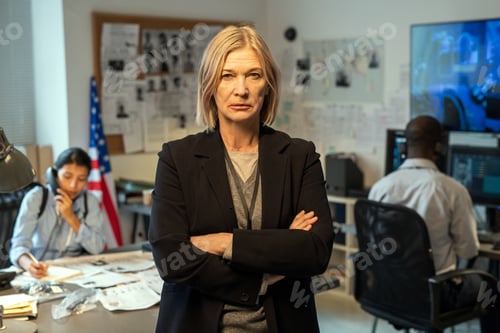 Preview: Serious mature leader of criminal department in formalwear standing in office