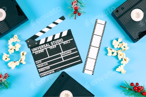 Preview: Three retro videotapes, fir branches with red berries, a clapperboard and popcorn on a blue