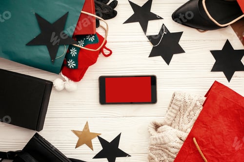 Preview: Phone with empty screen, bags, clothes and shoes, gift boxes