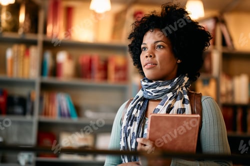 Preview: Portrait of black female adult student at university library looking away.