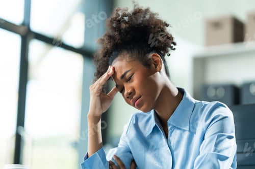 Preview: A young African American woman with Afro brown hair in a modern office experiencing panic