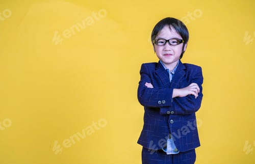 Preview: Portrait of young happy little asian boy in uniform isolated on yellow background