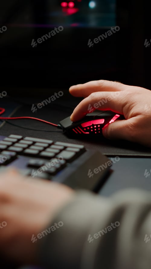 Preview: Close up hands shot of man player typing on RGB keyboard