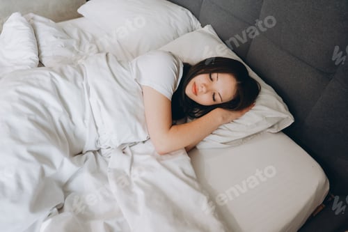 Preview: Teen girl sleeping peacefully in white bedsheets