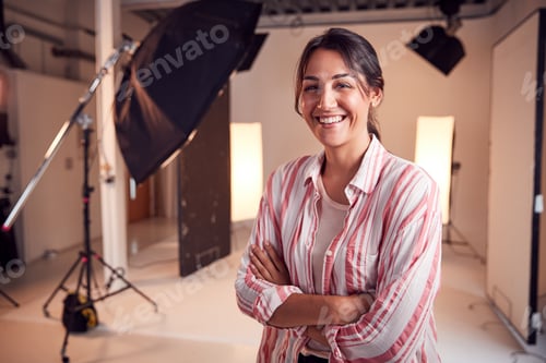 Preview: Portrait Of Smiling Female Photographer Standing In Studio With Lighting Equipment