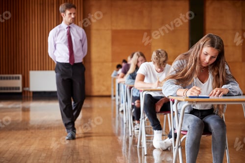 Preview: Teenage Students Sitting Examination With Teacher Invigilating