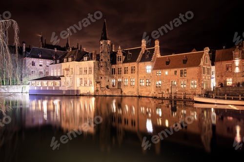 Preview: Nighttime view of historic buildings reflecting on the water in Brussels