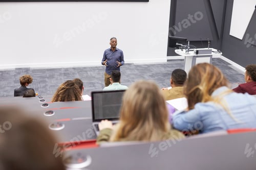 Preview: Man lectures students in lecture theatre, back row seat POV