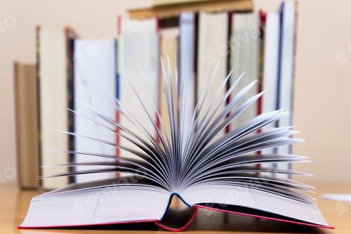 Preview: Open book on a the background of books.