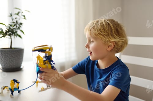 Preview: Preschooler boy playing with robot toy at home. Kids leisure activity.
