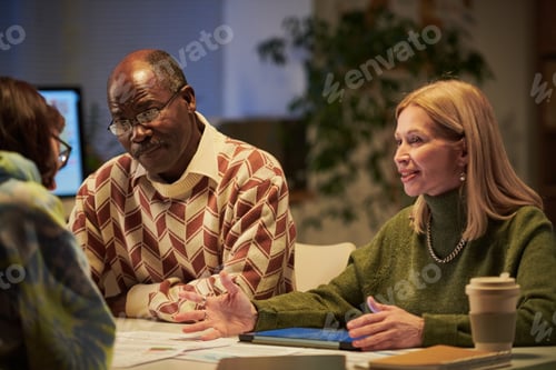 Preview: Senior Black Man and Woman Discussing Project at Office Table