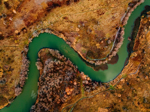 Preview: Aerial view of winding river and road in golden colored fall forest