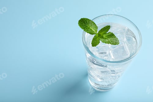 Preview: Glass of soda water with ice and mint on turquoise background. Space for text