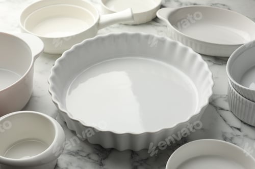 Preview: Different casseroles on white marble table, closeup