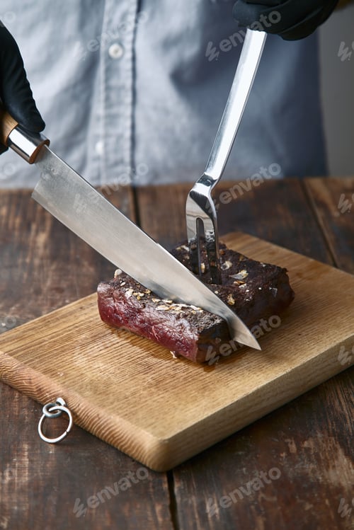 Preview: Hands cut medium rare cooked whale meat steak