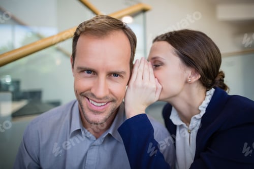 Preview: Â Businesswoman whispering something to her colleague