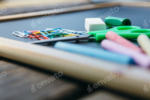 Preview: Office supplies and chalks on blackboard