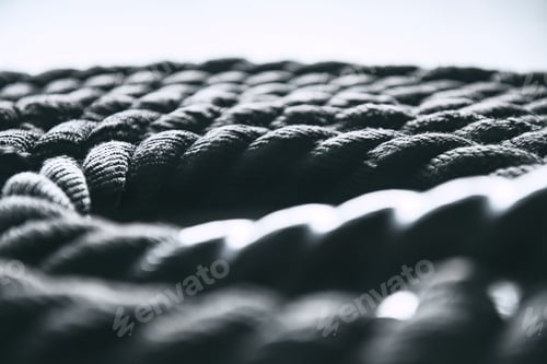 Preview: Close up of black battle rope on a gray backgound. Sport and fitness equipment.