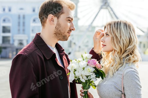 Preview: boyfriend touching girlfriend hair and they looking at each other in city