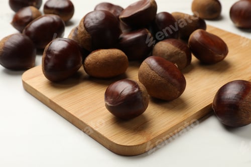 Preview: Sweet fresh edible chestnuts on white table, closeup