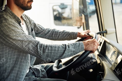 Preview: Close up view, sitting inside. Young truck driver in casual clothes