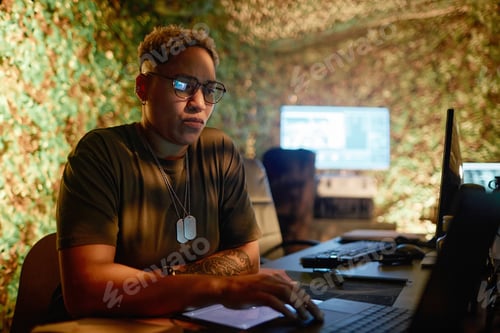 Preview: Focused Individual Working on Laptop in Office