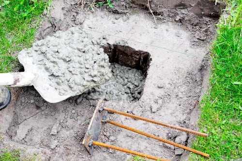 Preview: Worker builder man pour in cement solution with rubble, slurry, concrete mortar in pit or hole